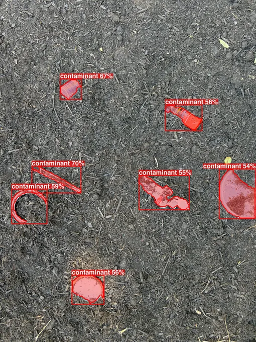 A close view of compost with seven partly buried plastic items outlined and flagged as likely contaminants