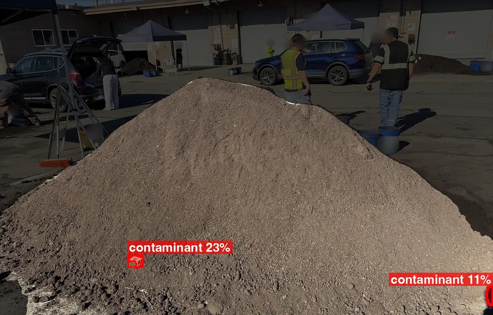A finished compost pile, with the background dimmed and two small items flagged as likely contaminants